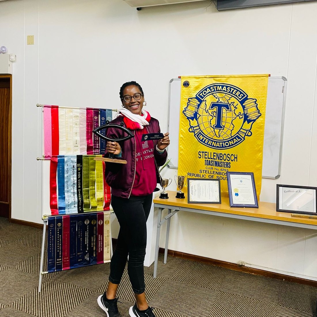 Deborah Kapenda holding a Best Table Topics award at Stellenbosch Toastmasters